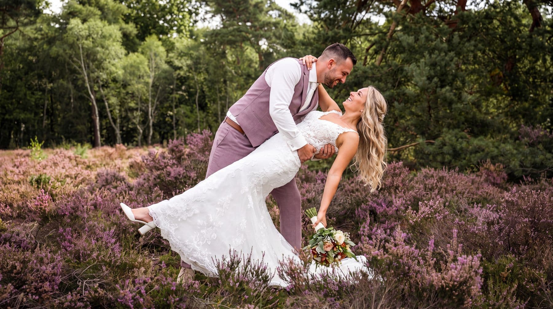 Bruidspaar danst tussen de paarse heide